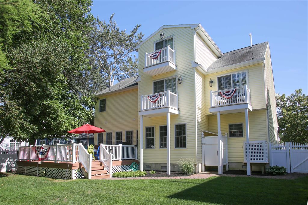 Rear of home with view of deck, balconies and shower